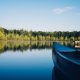 canoe on a lake with forest and clear blue sky