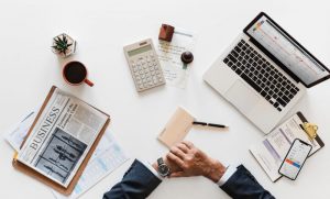 accountant sitting with computer, paper, coffee and other supplies