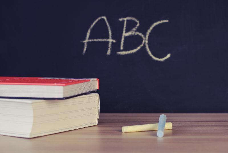 ABC on chalkboard with books and chalk