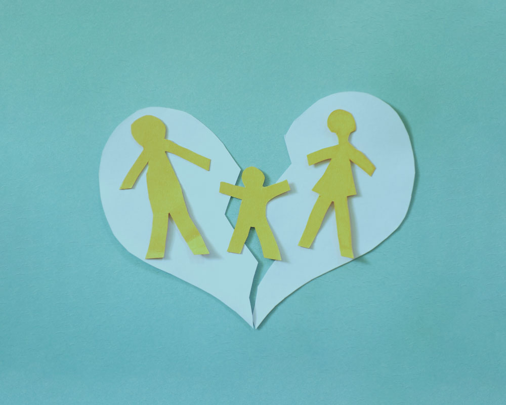 Broken paper heart with two parents and child divorce financial planning