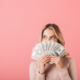 woman fanning money in front of her face