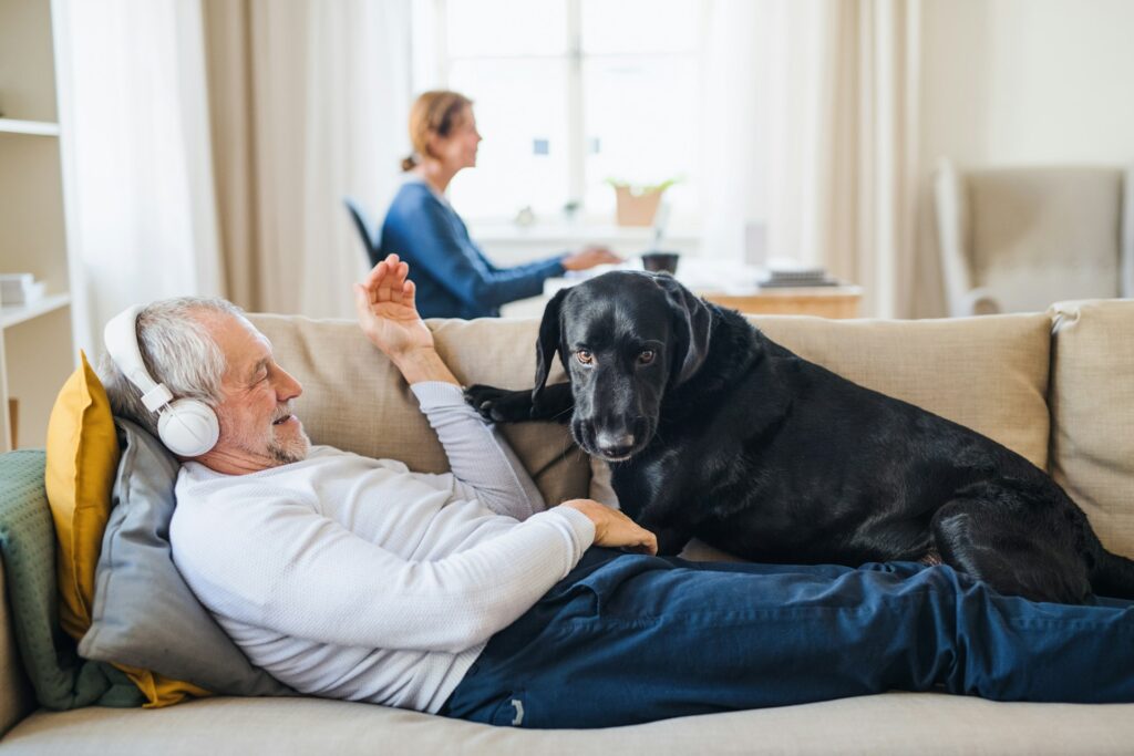 retired man on the couch with dog