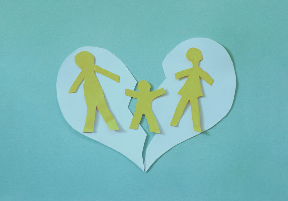 Broken paper heart with two parents and child divorce financial planning